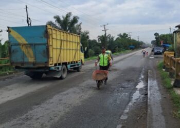 Personil Polres Tebingtinggi Lakukan lakukan Timbun Jalan Berlobang.