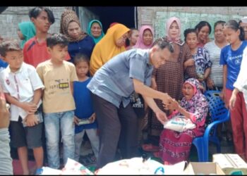 Sugito Saat Memberikan Bantuan Sembako Berupa Beras Kepada Kaum Dhuafah Di Kampung Pala , Desa Sei Rampah.