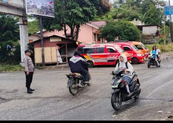 Dedikasi Tinggi Bhabinkamtibmas Polsek Dopar, Usai Sembuh Dari Sakit Langsung Atur Lalu Lintas di Tengah Hujan.