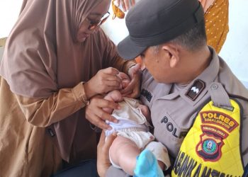 Bhabinkamtibmas Aipda H. Sinaga Dampingi Kegiatan “PENARI” di Bosar Maligas : Dukung Imunisasi Balita Demi Generasi Sehat.
