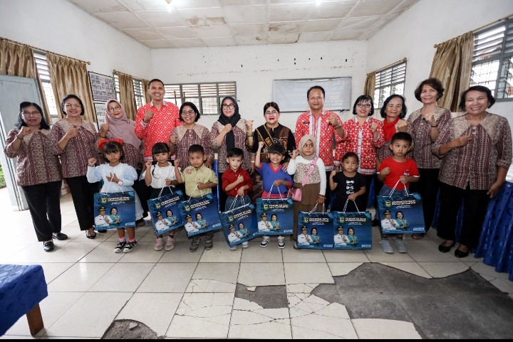 Ketua TP PKK Kota Pematangsiantar Yang Juga Ketua Penyelenggaran PAUD SAB Kota Pematangsiantar Ny Liswati Wesly Silalahi Serahkan Secara Simbolis Seragam & Pakaian Olahraga Kepada Murid PAUD SAB.