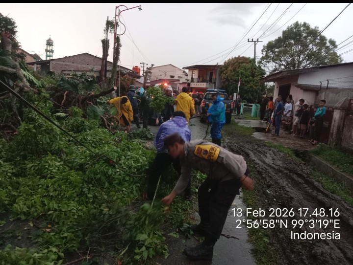 Bhabinkamtibmas Polsek Siantar Barat Respon Cepat Bantu Bersihkan Pohon Tumbang di Jalan Simbolon.