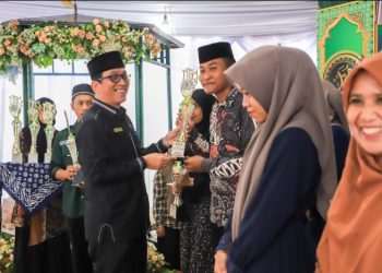 Wali Kota Pematangsiantar Wesly Silalahi, SH, MKn Diwakili Asisten Perekonomian dan Pembangunan Setdako Zainal Siahaan, SE, MM Serahkan Piala Juara Umum Kepada Kelurahan Martoba Yang Menjadi Juara Umum MTQN Ke - 55 Tingkat Kecamatan Siantar Utara.