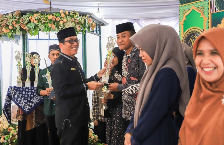 Wali Kota Pematangsiantar Wesly Silalahi, SH, MKn Diwakili Asisten Perekonomian dan Pembangunan Setdako Zainal Siahaan, SE, MM Serahkan Piala Juara Umum Kepada Kelurahan Martoba Yang Menjadi Juara Umum MTQN Ke - 55 Tingkat Kecamatan Siantar Utara.